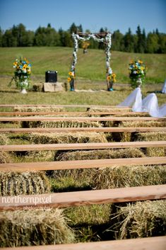 an outdoor ceremony with hay bales in the foreground