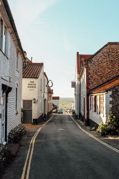 an empty street lined with white buildings and cobblestone streets in rural countryside area