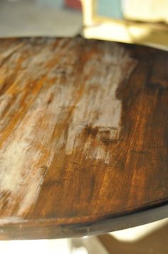 a close up of a wooden surfboard on top of a metal table with rusted paint