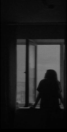 a woman standing in front of a window