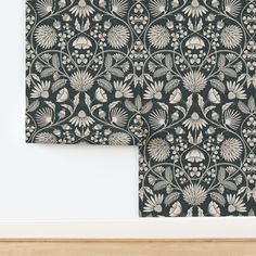 two black and white wallpapers with floral designs on them, one is folded to the side