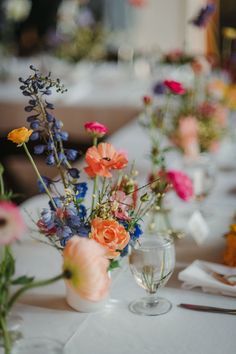 the table is set with flowers in vases