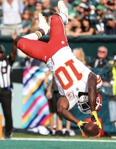 a football player diving into the air to catch a ball