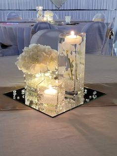 some candles are sitting on a table with flowers