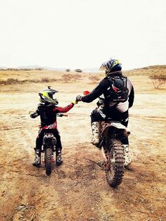 two people on dirt bikes in the desert