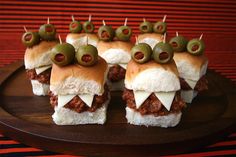 some sandwiches with olives on them and the words the vampire sandwich written in white letters