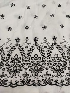 black lace on white fabric with flowers and leaves in the center, as well as an embroidered design