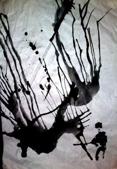 black and white photograph of tree branches on paper with ink splatters all over it