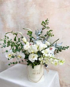 a white vase filled with flowers on top of a table