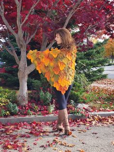 a woman standing in front of a tree with leaves on it's back and her arms wrapped around the neck