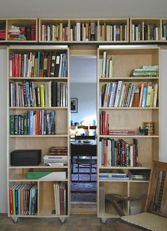 an open book shelf filled with lots of books next to a wall full of books