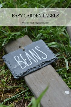 a slate sign that says easy garden labels on it sitting in the grass next to a lawn mower