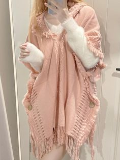 Introducing our enchanting knitted hooded cloak, a perfect blend of elegance and comfort. This exquisite piece boasts a stylish V-neck design, complemented by delicate fringe embellishments that add a touch of sophistication. The hem is gracefully adorned with tassels, creating a whimsical and chic look. Functional buttons on both sides allow for versatility and ease of wear. Ideal for layering over your favorite outfits, this cloak is a must-have addition to your wardrobe.  Please note, the pri Cozy Winter Poncho With Fringe, Casual Knitted Winter Shawl, Knit Poncho For Cold Weather, Pink Shawl For Fall, Pink Shawl Poncho For Winter, Cozy Pink Poncho For Fall, Pink One Size Shawl For Winter, Pink One-size Winter Shawl, One Size Pink Shawl For Winter