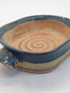 a blue and brown ceramic bowl with handles