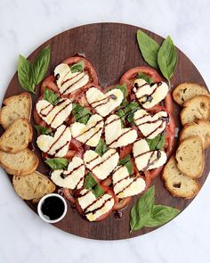 a heart shaped sandwich with mozzarella and basil leaves on a wooden platter