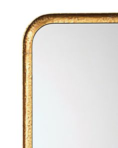 a gold framed mirror sitting on top of a table