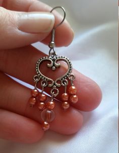 Beautiful, handmade earrings. Made with copper colored plastic beads, hung from an intricate sterling silver plated heart-shaped connector. These earrings would make the perfect gift for a special person's Birthday, Anniversary, or just to say "I'm thinking of you". *Size: about 2 inches long by 3/4 inch wide. * Very light weight. We do many custom orders and would love the chance to help you with the perfect gift! Metal Heart Beaded Earrings For Gifts, Metal Heart Beads Earrings For Gifts, Heart Beads Metal Earrings For Gift, Gift Metal Heart Earrings With Heart Beads, Heart Beaded Metal Earrings As Gift, Metal Heart Bead Earrings As Gift, Heart Beads Metal Earrings As Gift, Heart-shaped Earrings With Dangling Beads For Gifts, Nickel Free Copper Chandelier Earrings As Gift