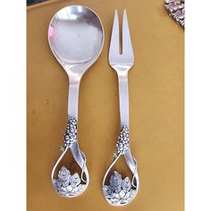 two spoons and a fork sitting next to each other on top of a table