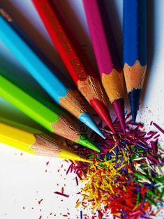 a group of colored pencils sitting next to each other