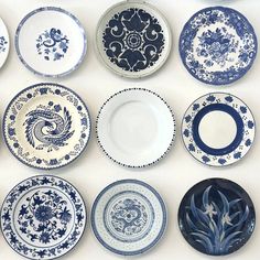 many blue and white plates are arranged on the wall