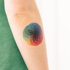 a woman's arm with a colorful tattoo on the left side of her arm