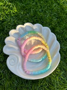 three bracelets are sitting on a plate in the grass