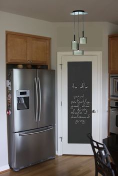 a kitchen with a chalkboard on the wall next to a refrigerator and stove top oven