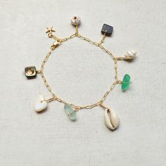 "This beautiful ocean inspired charm bracelet has an assortment of shells and cultured sea glass dangling from a textured cable chain and finished with a tiny gold filled starfish at the end. This bracelet is meant to dangle so I add 1/2\" to the length you order. Please allow for variations in size and shape of shells and sea glass." Gold Charm Bracelet With Starfish For Beach, Beach Ocean-inspired Charm Bracelet, Ocean-inspired Starfish Charm Bracelet For Beach, Bohemian Charm Bracelet For Beach With Lobster Clasp, Bohemian Charm Bracelet For The Beach, Pearl Bangles Gold, Sea Shell Bracelet, Bracelet Ocean, Beachy Bracelets