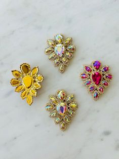 three pieces of brooch sitting on top of a marble counter