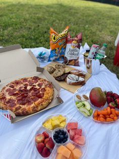 a pizza sitting on top of a table covered in fruit and vegtables