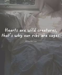 a person laying in bed with the words hearts are wild creatures, that's why ribs are cages