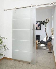 the sliding glass door is open to reveal a room with a potted plant in it