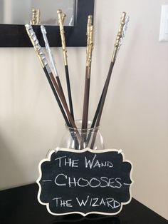 a sign that says the wands choose the wizard in front of a glass vase with some writing on it