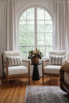 two chairs and a table in front of a large window