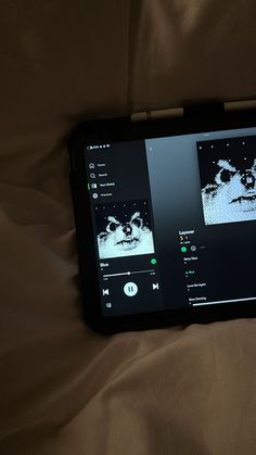 a tablet computer sitting on top of a bed next to a brown sheet covered ground