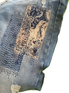 an old pair of jeans with patches and holes on them are laying side by side