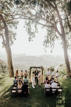 a group of people sitting in chairs under trees