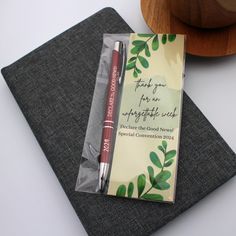 a notepad with a pen on it next to a wooden bowl and napkins