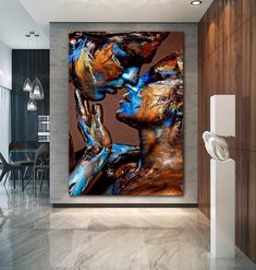 an abstract painting on the wall of a modern living room with two women kissing each other