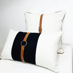 two black and white pillows sitting on top of a bed next to eachother