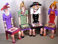 four dolls sitting in chairs made to look like women