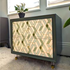 a green and white cabinet sitting on top of a rug next to a potted plant