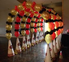 a bunch of balloons that are on top of some white and black cones in the middle of a room