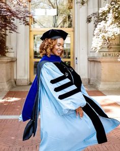 a woman in a graduation gown is walking outside