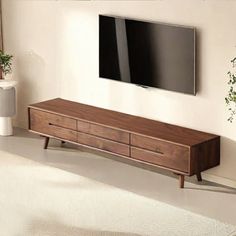 a flat screen tv mounted to the side of a wooden cabinet in a living room