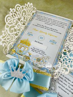 a wedding card with a tiara on it and ribbon tied around the edge, surrounded by other items