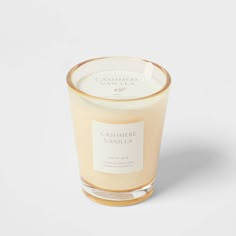 a candle that is sitting on a white surface with the words cashmere vanilla in front of it