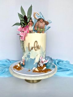 there is a cake decorated with figurines and flowers