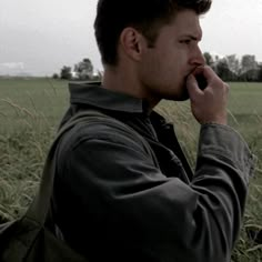 a man talking on a cell phone in a field