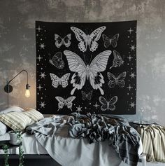 a black and white butterfly tapestry hanging on the wall above a bed in a bedroom